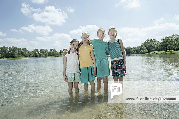 Group of friends standing in the lake  Bavaria  Germany