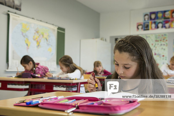 Schulmädchen  die in einem Klassenzimmer Hefte schreiben  München  Bayern  Deutschland
