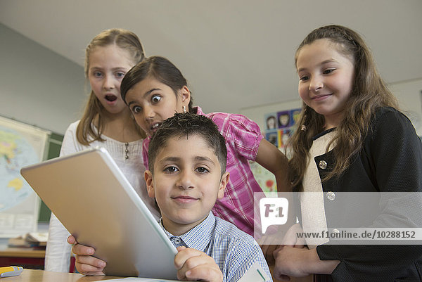 School children using a digital tablet in a classroom  Munich  Bavaria  Germany