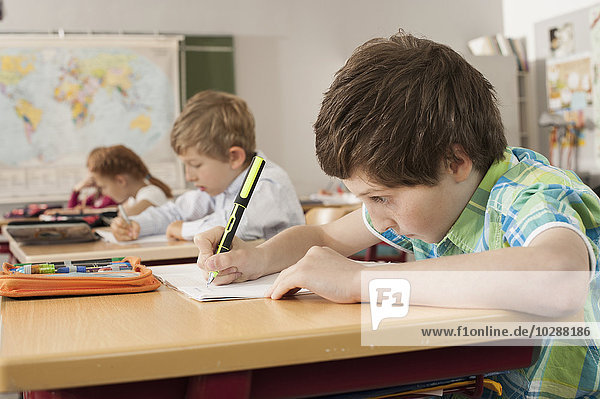 School students writing in notebooks  Munich  Bavaria  Germany