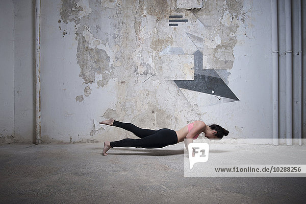 Mittlere erwachsene Frau beim Üben der Plank-Pose im Yoga-Studio  München  Bayern  Deutschland