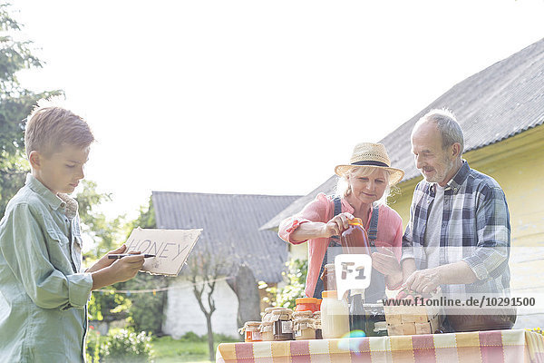 Großeltern und Enkel bereiten sich auf den Honigverkauf vor