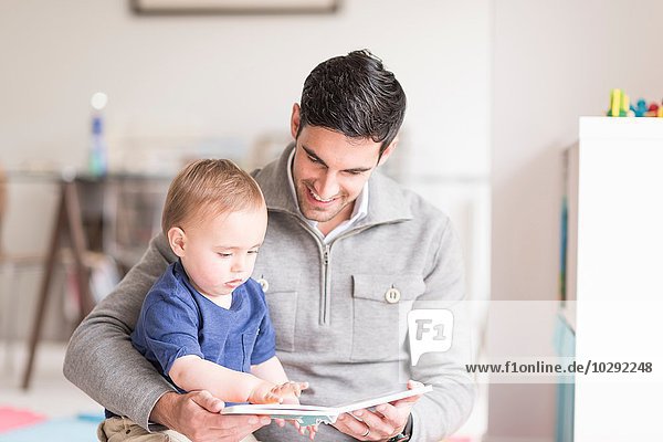 Vater und kleiner Sohn lesen gemeinsam Buch