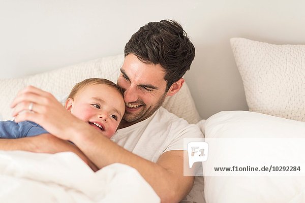 Father and young son laughing together  indoors