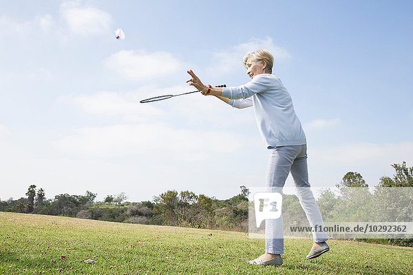 Seniorin spielt Badminton im Park
