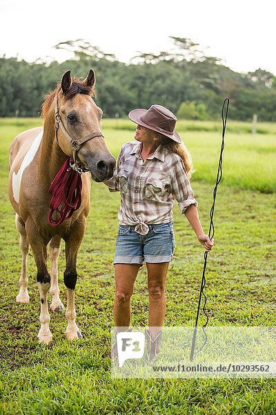 Portrait of mature woman standing beside horse