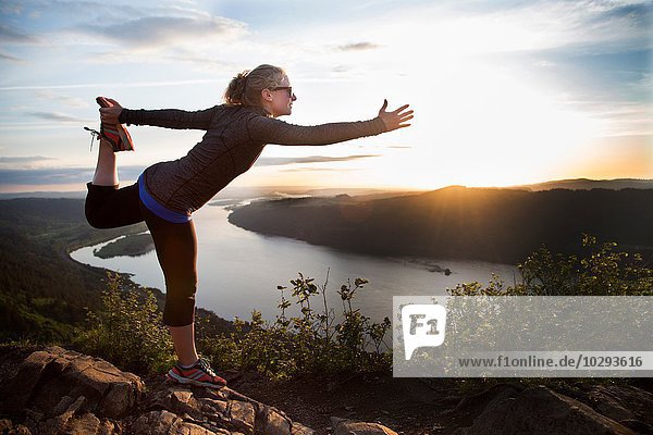 Woman practising yoga on hill  Angel's Rest  Columbia River Gorge  Oregon  USA