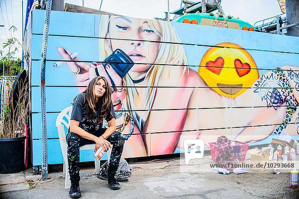 Graffitikünstlerin sitzend an einer bemalten Wand  Venice Beach  Kalifornien  USA