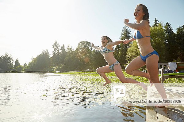 Mädchen im Bikini springen in den See  Seattle  Washington  USA