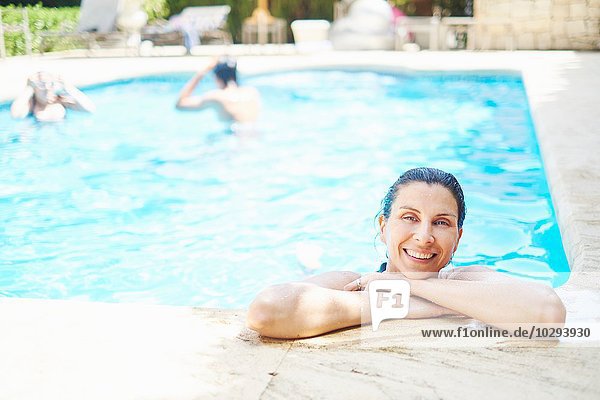 Porträt der lächelnden reifen Frau mit nassen Haaren im Schwimmbad
