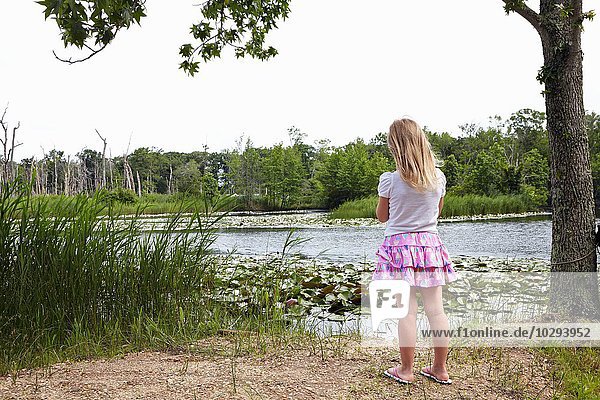 Rückseite des Mädchens mit Blick auf den ländlichen See