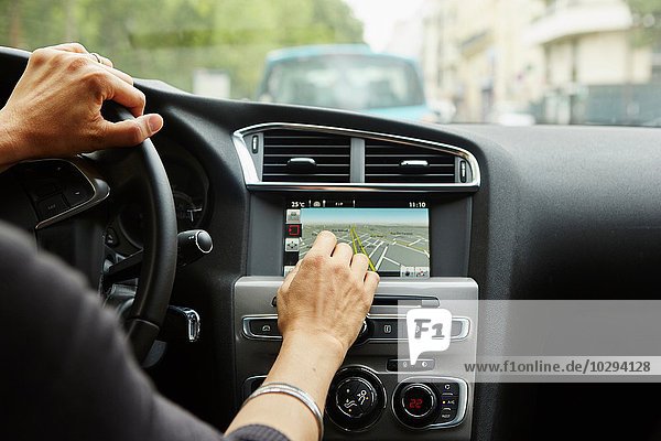 Woman sitting in car  using gps  focus on hands