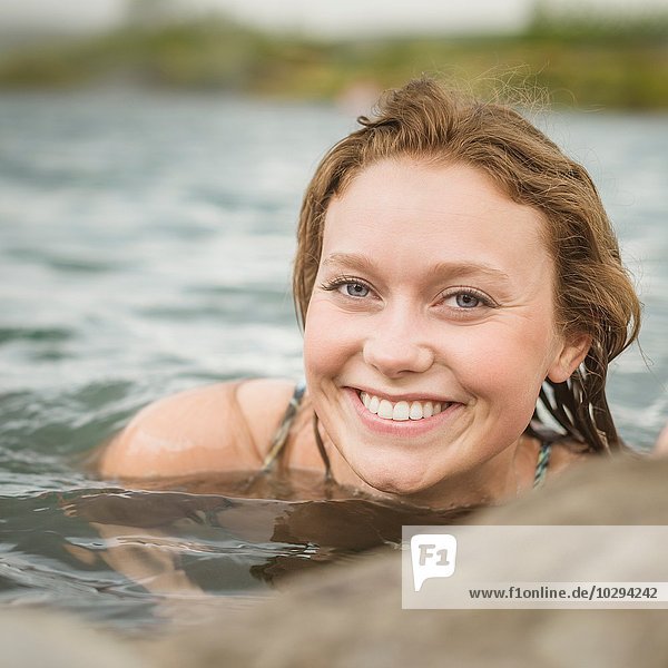 Nahaufnahme des Porträts einer jungen Frau  die sich in der Secret Lagoon Thermalquelle (Gamla Laugin)  Fludir  Island  entspannt.
