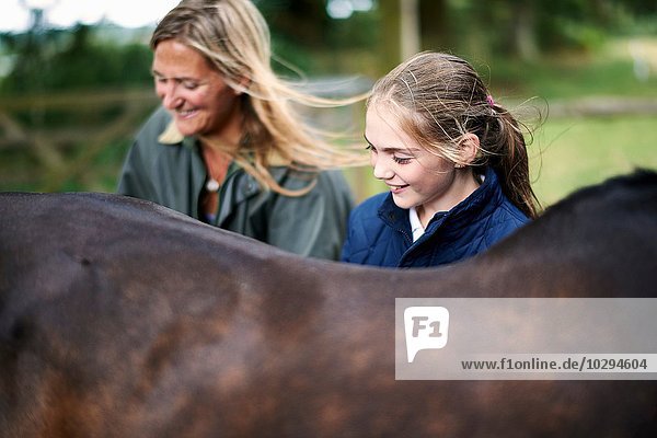 Mädchen und Mutter pflegendes Pferd