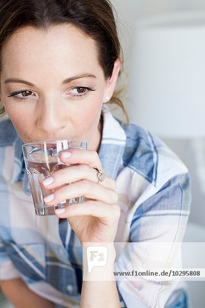 Abgeschnittene Ansicht einer reifen Frau  die ein Glas Wasser trinkt.