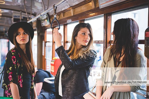 Drei junge Frauen reisen mit der Stadtbahn