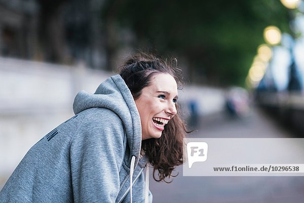 Portrait of happy female runner taking a break on riverside