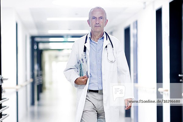 Male doctor walking along corridor
