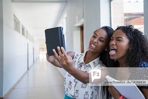 Students standing in hallway  taking selfie