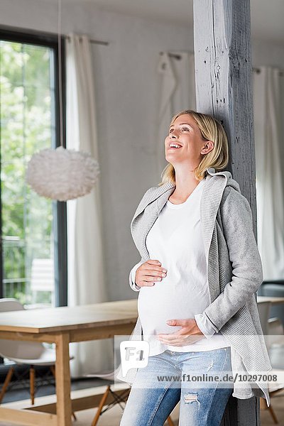 Vollzeitschwangerschaft junge Frau in der Küche  die ihren Bauch hält