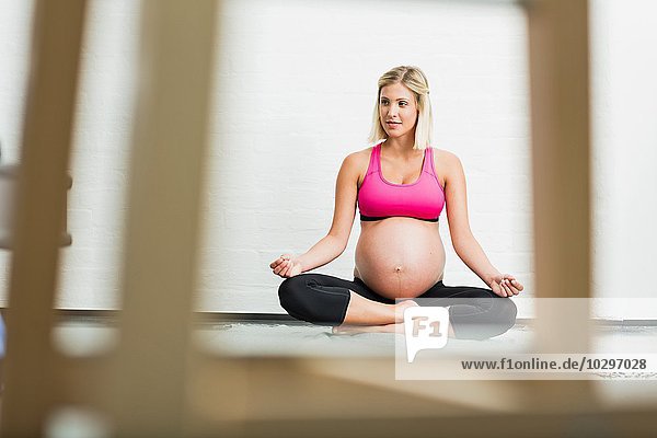 Vollzeitschwangerschaft junge Frau praktiziert Yoga