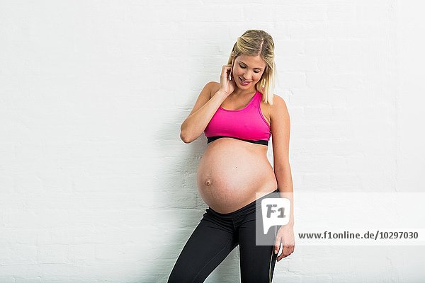 Vollzeitschwangerschaft junge Frau in Sportbekleidung