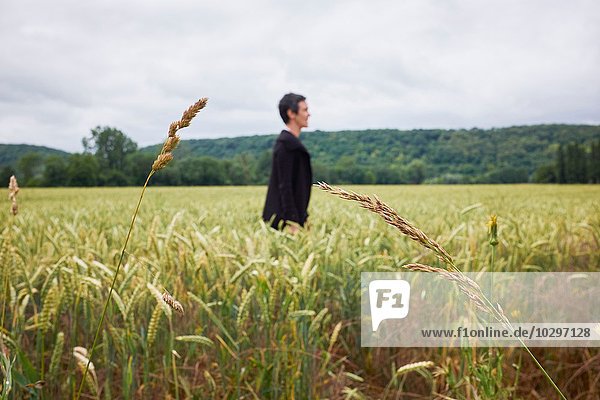 Side view of woman standing in cornfield