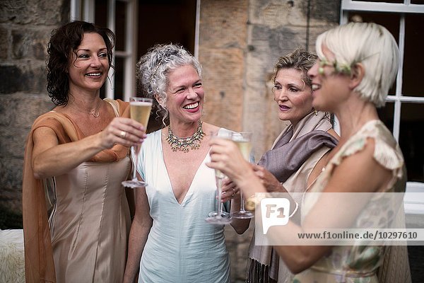 Elegant mature women enjoying champagne in urban garden