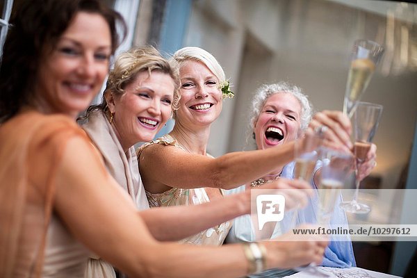 Elegant mature women toasting in urban garden
