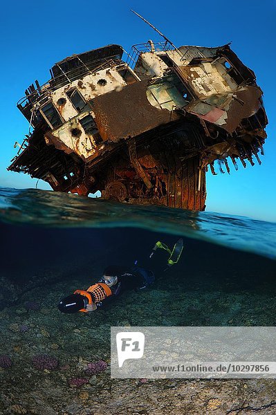 Ein Apnoetaucher, auch Freitaucher, schwimmt mit einem Unterwasserscooter an einem Wrack, Rotes Meer, Ägypten, Afrika
