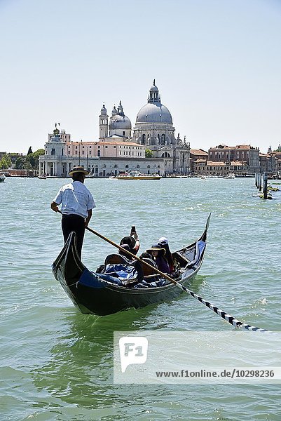 Gondel mit Touristen und Gondoliere vor der Kirche Santa Maria della Salute  Venedig  Venezia  Venetien  Italien  Europa