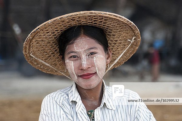 Einheimische Frau mit Strohhut und Thanaka-Paste im Gesicht  lächelt  Portrait  Ngapali  Thandwe  Rakhine-Staat  Myanmar  Asien