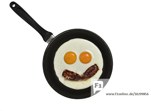 Fried eggs with bacon in pan  face with eyes