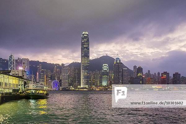 Skyline von Hong Kong und Star Ferry Pier in der Abenddämmerung Tsim Sha Tsui Kowloon Hongkong China Asien