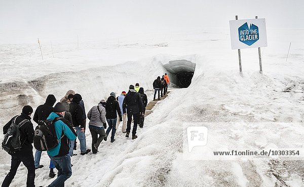 Tourists walking in to glacial cave  Into the Glacier  Langjökull Glacier  Húsafell  West Iceland  Iceland  Europe