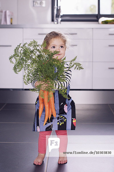 Kleines Mädchen mit frischen Karotten