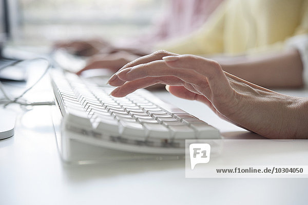 Woman's hands typing on a computer keyboard