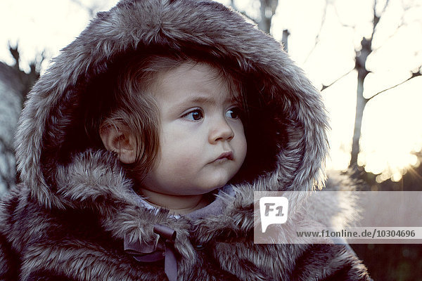 Baby wearing fur coat outdoors  portrait