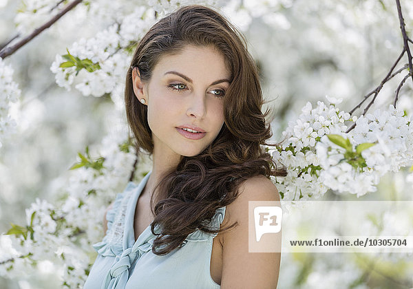 Junge Frau vor Blütenbaum  Porträt