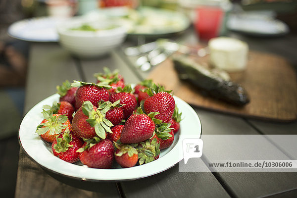 Picknicktisch mit gedeckter Mahlzeit. Ein Platz mit frischen Erdbeeren.