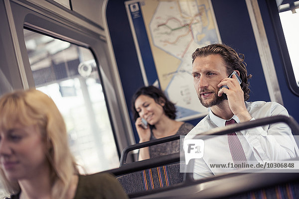 Drei Personen in einem Bus  zwei telefonieren mit ihren Handys