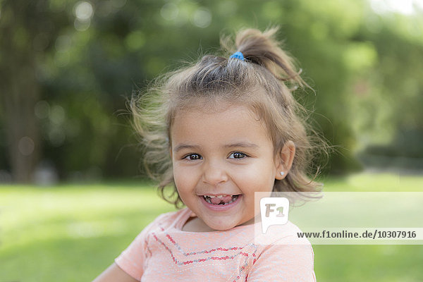 Portrait of smiling little girl in a park