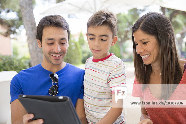 Eltern und kleiner Sohn beim Betrachten des digitalen Tabletts