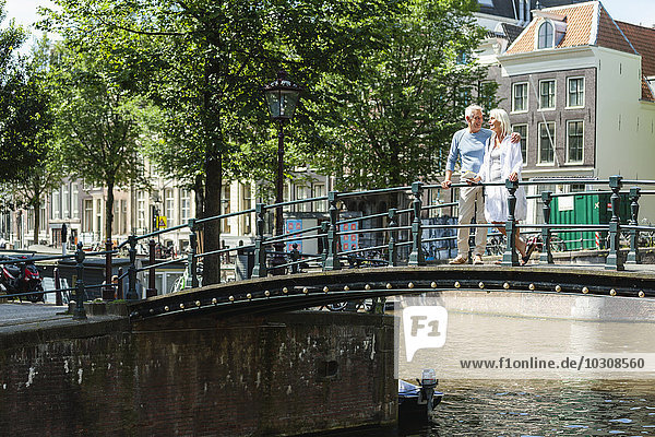 Netherlands  Amsterdam  senior couple walking on a bridge
