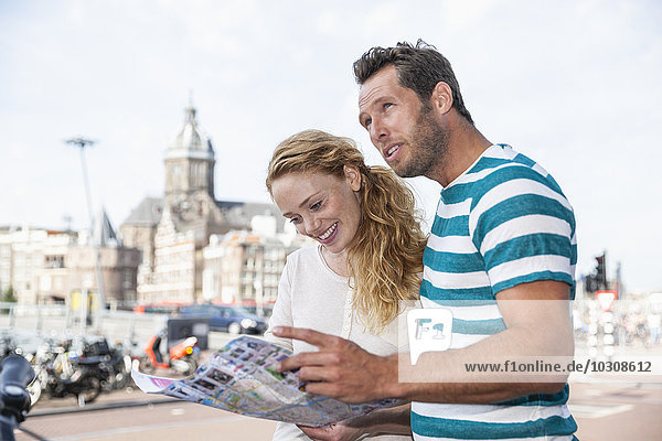 Niederlande  Amsterdam  Paar mit Karte sucht Richtung