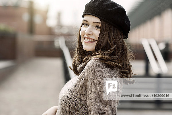 Portrait of smiling young woman wearing beret and knitted dress