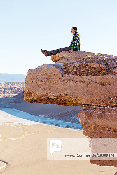 Chile  Atacama-Wüste  Frau auf einer Klippe sitzend mit Blick auf die Aussicht