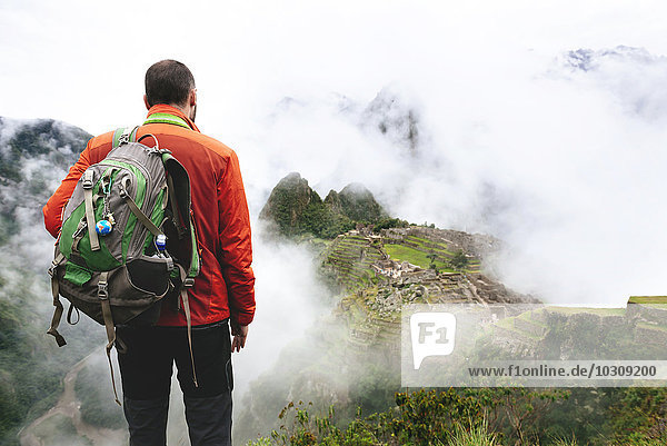Peru  Machu Picchu Region  Reisender mit Blick auf Machu Picchu Zitadelle und Huayna Berg