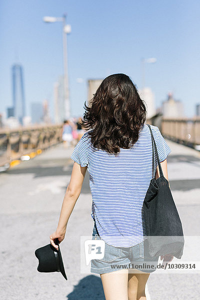 USA  New York City  Rückansicht der jungen Frau auf der Brooklyn Bridge