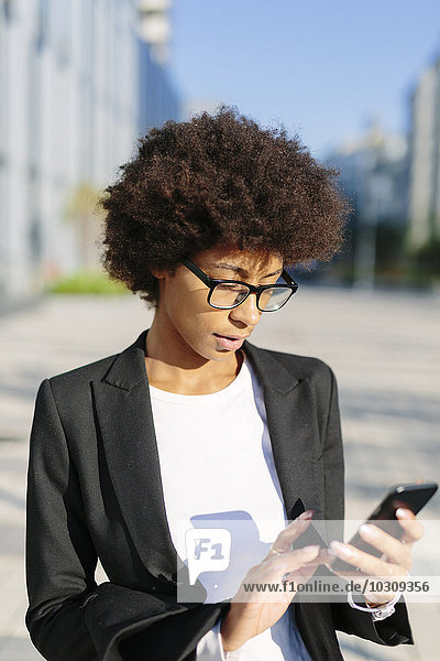 USA  New York City  businesswoman looking at her smartphone